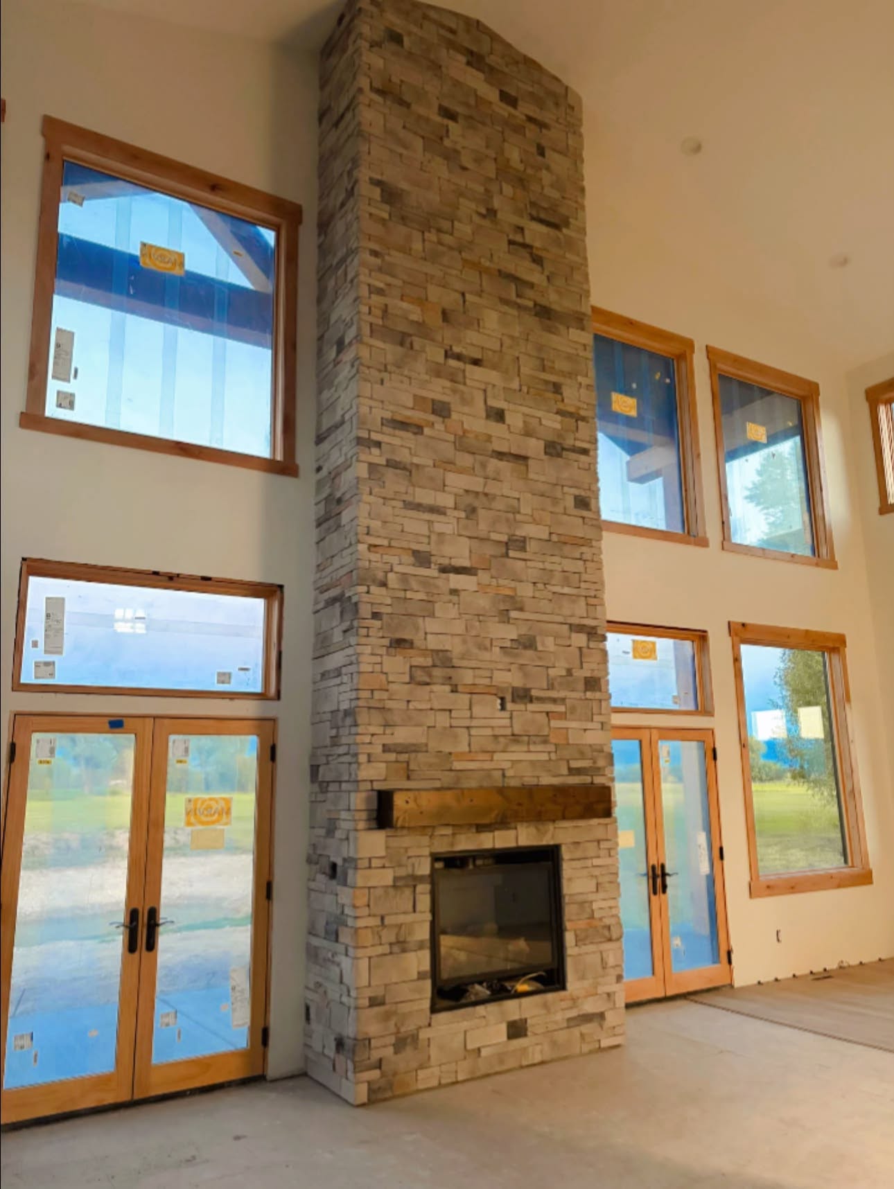 Tall stone fireplace in an interior under construction